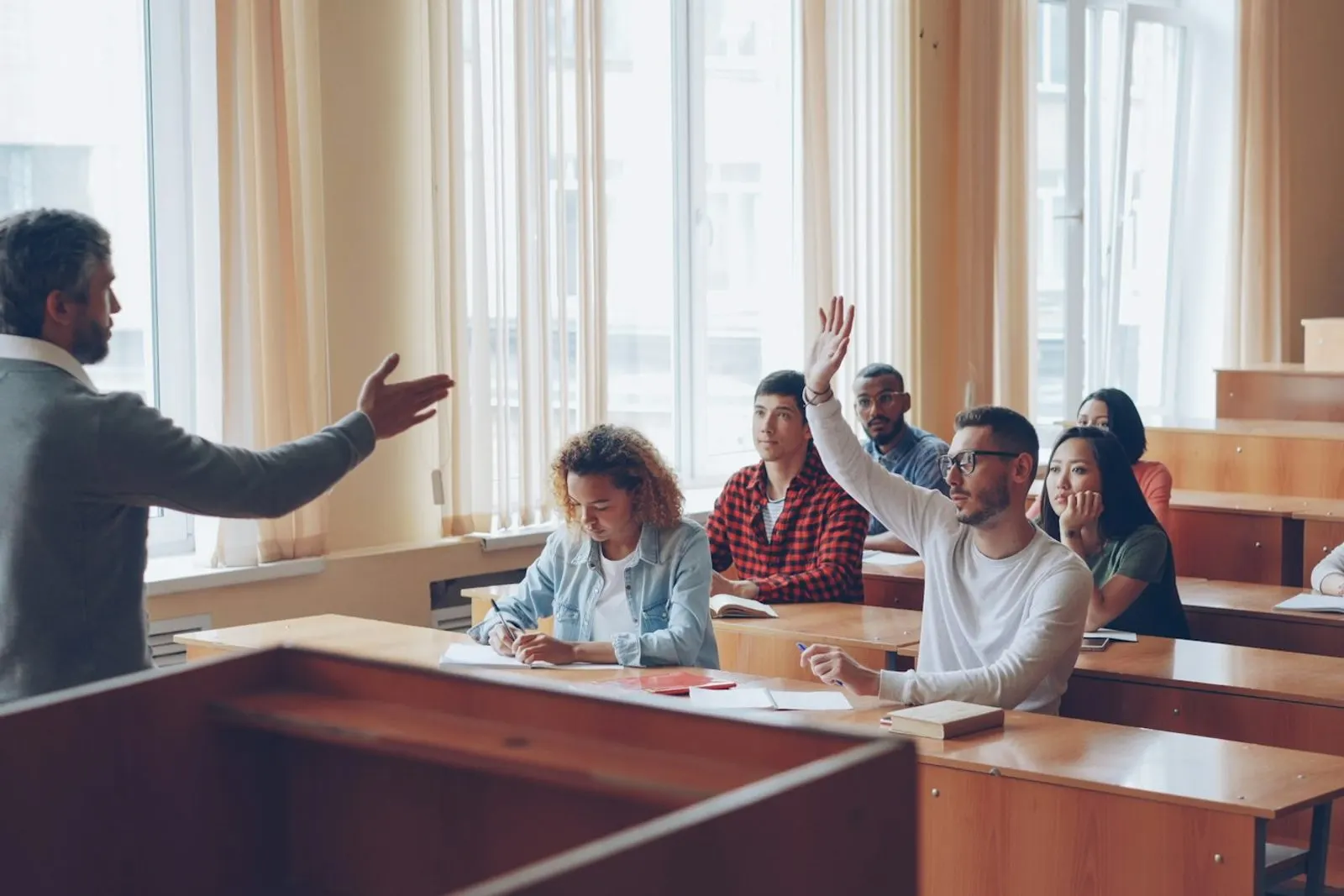Alumnos levantando la mano en clase